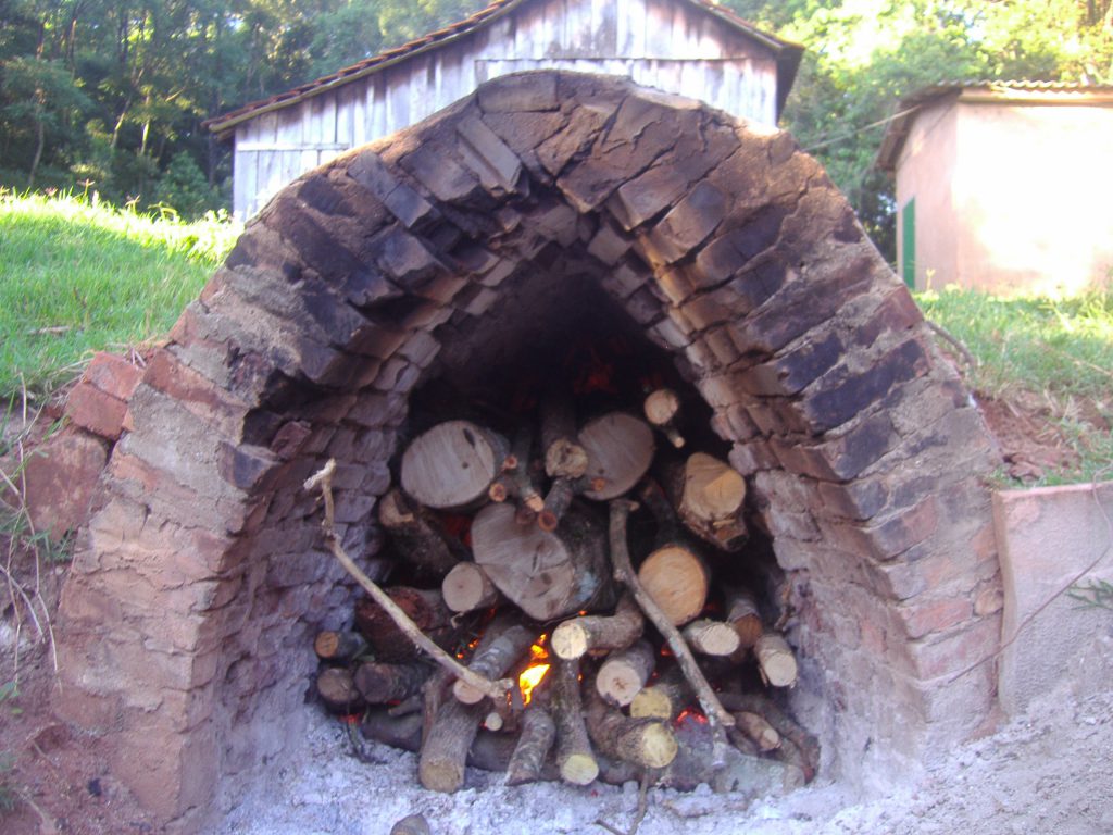 The smoke from the fire travels through the tunnel to dry the mate in the wooden structure pictured in the background